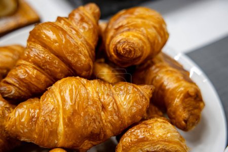 Photo for Freshly baked croissants in a white plate on a table - Royalty Free Image