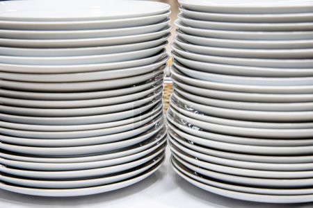 Photo for Stack of white plates on a shelf in a restaurant, closeup of photo - Royalty Free Image