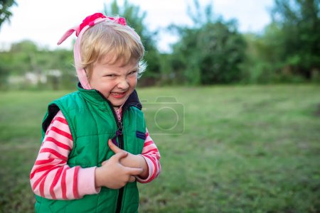 Téléchargez les photos : Petite fille drôle en colère dans la gelée verte sur fond d'herbe . - en image libre de droit
