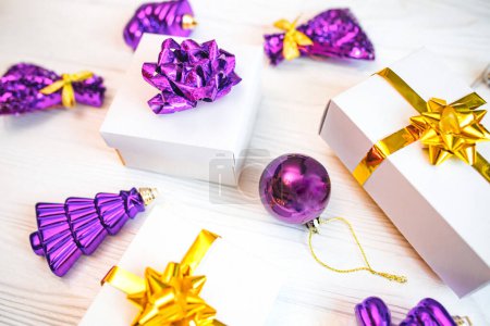 Photo for White gift boxes with purple christmas d cor on white table. - Royalty Free Image