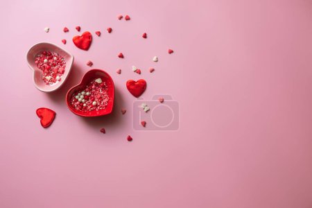 Téléchargez les photos : Contexte de la Saint-Valentin. Conteneurs pour saupoudrer en forme de coeur sur fond rose. - en image libre de droit