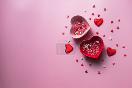 Téléchargez les photos : Contexte de la Saint-Valentin. Conteneurs pour jimmies en forme de coeur sur fond rose. - en image libre de droit