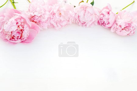 Photo for Delightful bouquet of blooming peonies on a white table. Top view. Empty space for your text. - Royalty Free Image