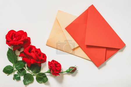 Foto de Rosas rojas y sobres sobre fondo blanco. Concepto de San Valentín. - Imagen libre de derechos