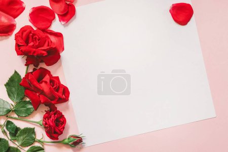 Téléchargez les photos : Fond Saint-Valentin avec des roses rouges et carte blanche sur fond rose - en image libre de droit