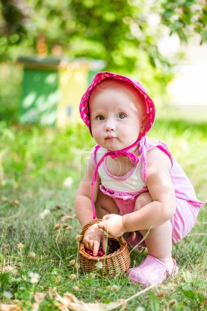 Photo for Toddler enjoys a healthy snack in the summer sun, picking cherries in orchard, her tiny hands stained red from the juicy fruits. Cultural Tradition concept - Royalty Free Image