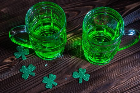 Foto de Dos vasos de cerveza verde irlandesa, evocando el animado ambiente de celebración en un pub tradicional. Concepto del Día de San Patricio - Imagen libre de derechos