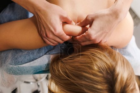 Téléchargez les photos : Massage apaisant du dos d'un masseur qualifié dans une retraite spa paisible. Concept de massage thérapeutique - en image libre de droit