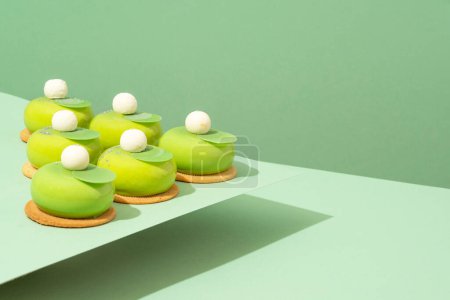Photo for A platter of assorted green donut treats sits atop a wooden table - Royalty Free Image