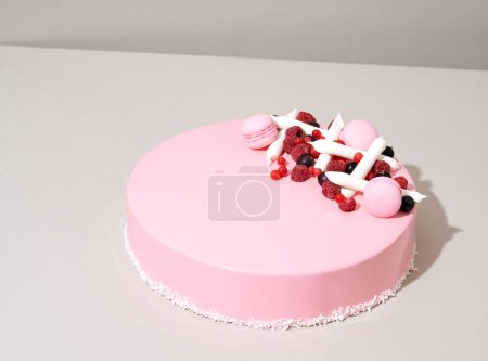 Foto de Un apetitoso pastel rosa con fresas blancas adornando la parte superior se sienta invitadamente en una mesa - Imagen libre de derechos