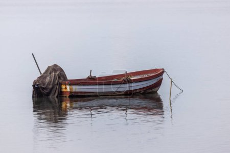 Foto de Barco de pesca de color rojo con una franja blanca en un mar - Imagen libre de derechos