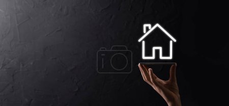 Photo for Male hand holding house icon on blue background. Property insurance and security concept.Real estate concept.Banner with copy space - Royalty Free Image