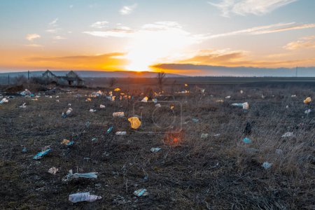 Téléchargez les photos : Urban garbage in polluted field at sunset. Environmental concept. - en image libre de droit