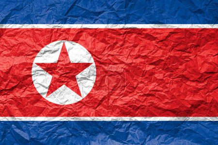 Flag of North Korea on crumpled paper. Textured background.