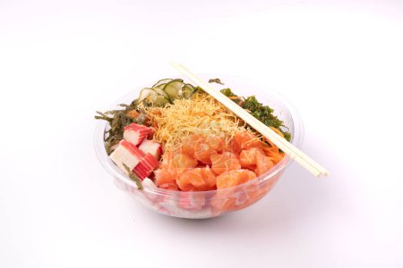 Foto de Tazón de comida japonesa oriental y kani aislado sobre fondo blanco salmón en ángulo crudo con un par de palillos - Imagen libre de derechos
