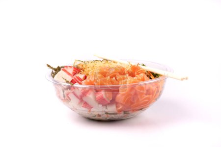 Foto de Tazón de comida japonesa oriental y kani aislado sobre fondo blanco salmón crudo en frente con un par de palillos - Imagen libre de derechos