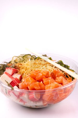 Foto de Tazón de comida japonesa oriental y kani aislado sobre fondo blanco salmón crudo macro primer plano con un par de palillos - Imagen libre de derechos