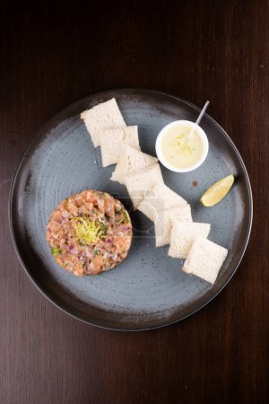 Téléchargez les photos : Tartare de saumon cru avec sauce grillée et vue sur le citron - en image libre de droit