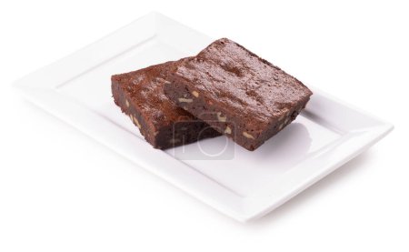 two pieces of organic chocolate brownie with nuts on white ceramic plate isolated