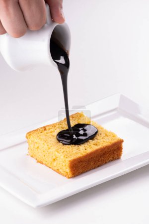 assiette blanche avec gâteau à la carotte main versant du chocolat garniture de près