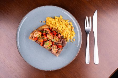 Foto de Filete de solomillo perfecto con ensalada de tomate cherry y farofa en una cena en el asador con vista superior - Imagen libre de derechos