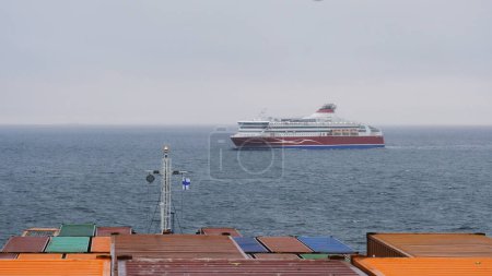 Téléchargez les photos : Mer Baltique, Europe - 10 11 2022 : Navire porte-conteneurs à l'ancre au large des côtes finlandaises et traversier à passagers traversant sa proue. - en image libre de droit