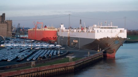 Foto de Emden, Germany - 02 04 2023: Two pure car carriers in the port during the loading and unloading of the vehicles and military equipment - Imagen libre de derechos