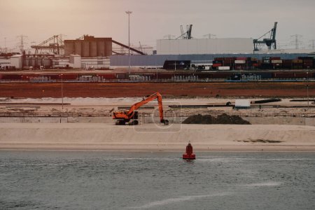 Foto de Puerto de Rotterdam, Países Bajos - 05 30 2023: Expansión del muelle en el puerto de Rotterdam. Mantenimiento y construcción de puertos. Inversión industrial. Trabajo en los Países Bajos. Desarrollo de la zona portuaria. - Imagen libre de derechos
