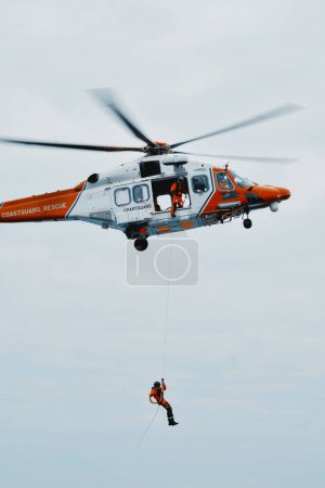 Foto de Mar del Norte, Europa - 08 08 2023: Seguridad marítima en el mar. Helicóptero guardacostas en escena. Asistencia a personas y buques en peligro. Coordinación de evacuaciones médicas en el mar. Seguridad en el mar. - Imagen libre de derechos