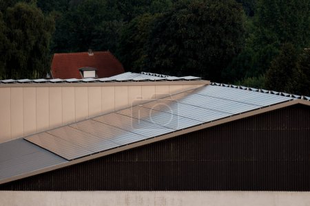 Téléchargez les photos : Entrepôt avec panneaux solaires sur le toit. Énergie produite par la nature. Énergie produite par le soleil. Systèmes photovoltaïques sur la maison de grange dans la campagne. Technologie des semi-conducteurs. Empreinte carbone. - en image libre de droit