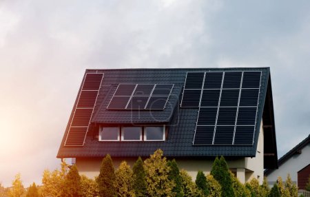 Maison avec panneaux solaires sur le toit. Énergie produite par la nature. Énergie produite par le soleil. Systèmes photovoltaïques sur la maison de grange dans la campagne. Concept d'énergie renouvelable
