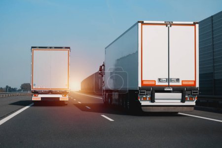 Photo for Two modern semi-trailer trucks on the highway driving and overtaking each other. Commercial vehicle for shipping and post delivery. Shipping of the goods on land door-to-door - Royalty Free Image