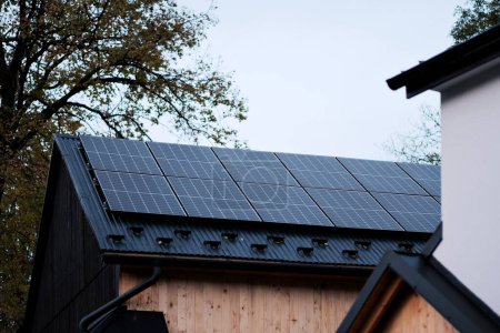 Téléchargez les photos : Le toit de la maison avec des panneaux solaires sur le toit. Énergie produite par la nature. Énergie produite par le soleil. Systèmes photovoltaïques sur la maison de grange dans la campagne. Le concept d'énergie renouvelable - en image libre de droit