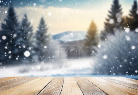 Téléchargez les photos : Une mise au point sélective sur un dessus du bureau de table en bois recouvert de neige et de glace avec les arbres de Noël dans le fond flou Bokeh. Visualisation et présentation de l'esprit de Noël. - en image libre de droit