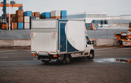 Foto de Cargo Truck In The Port. Modern Commercial Vehicle With Hydraulic Remotely Operated Ramp. Commercial Vehicle For Door-To-Door Goods And Post Delivery. Logistics Transport With Good Capacity - Imagen libre de derechos