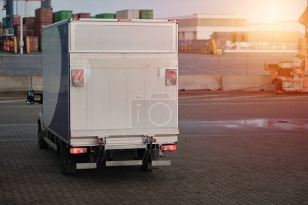 Foto de Cargo Truck In The Port. Modern Commercial Vehicle With Hydraulic Remotely Operated Ramp. Commercial Vehicle For Door-To-Door Goods And Post Delivery. Logistics Transport With Good Capacity - Imagen libre de derechos