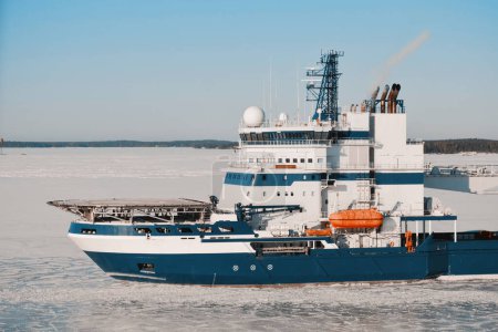 Téléchargez les photos : Navire brise-glace en service pour les services de déglaçage pour une navigation sécuritaire. Opérations dans les zones arctiques. Navire avec pont d'hélicoptère - en image libre de droit