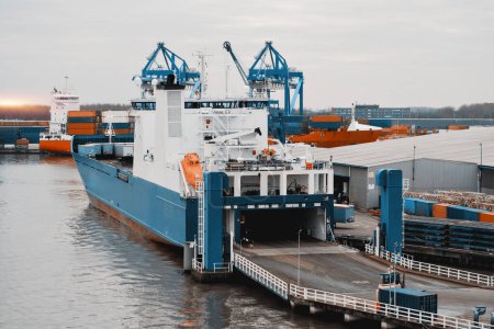 RO-RO Proceso de carga de buques en el puerto comercial. Rampa hidráulica trasera abierta durante las operaciones de carga