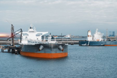 Photo for Marine Loading Arm And Crude Oil Carrier Tanker In The Harbour Engaged In Cargo Operations - Royalty Free Image