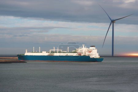 LNG-Tanker im Handelshafen mit einem Windgenerator im Hintergrund