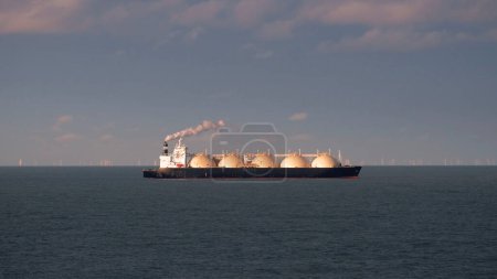 LNG Tanker With Smoke Emission From Exhaust Funnel At Sunset