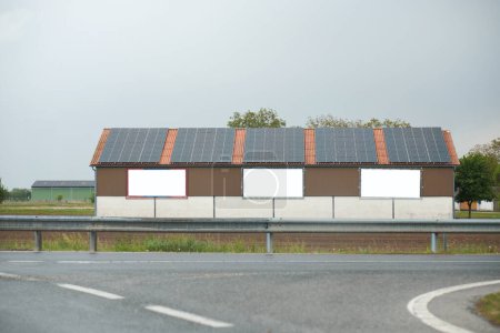 Téléchargez les photos : Entrepôt avec panneaux solaires sur le toit. Énergie produite par la nature. - en image libre de droit