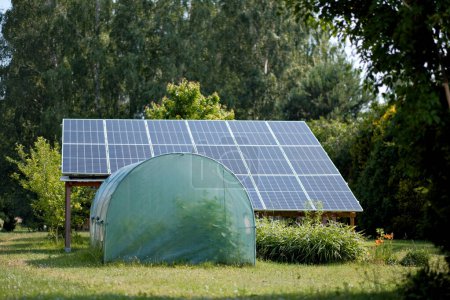 Gewächshaus mit Sonnenkollektoren für die Elektrizitätsproduktion im privaten Hof