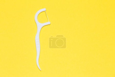 Téléchargez les photos : Cure-dent en plastique sur fond jaune isolé. Hygiène et soins dentaires. - en image libre de droit