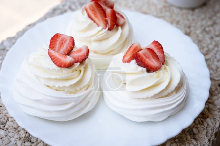 Téléchargez les photos : Dessert meringue maison Pavlova gâteau aux fraises fraîches et menthe. Dessert d'été. Du gâteau français. Des confiseries. Un dessert classique. Dessert aux fraises - en image libre de droit