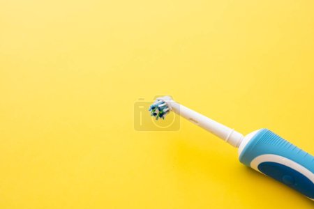 Téléchargez les photos : Brosse à dents électrique intelligente sur fond jaune gros plan. Buse pour brosser les dents. - en image libre de droit