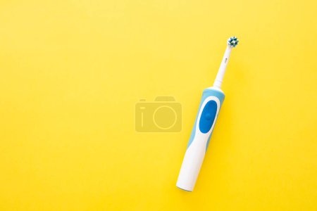 Téléchargez les photos : Brosse à dents électrique intelligente sur fond jaune gros plan. Buse pour brosser les dents. - en image libre de droit