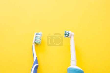 Téléchargez les photos : Brosse à dents électrique sur fond jaune. Ancien et nouveau compte dentaire. - en image libre de droit