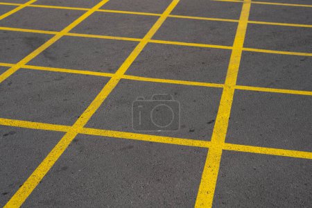 Photo for Diagonal yellow lines forming a grid at an asphalt road. Prohibition on parking and stopping a car. - Royalty Free Image