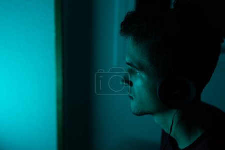 Foto de Retrato de un jugador en auriculares con luz azul neón. - Imagen libre de derechos